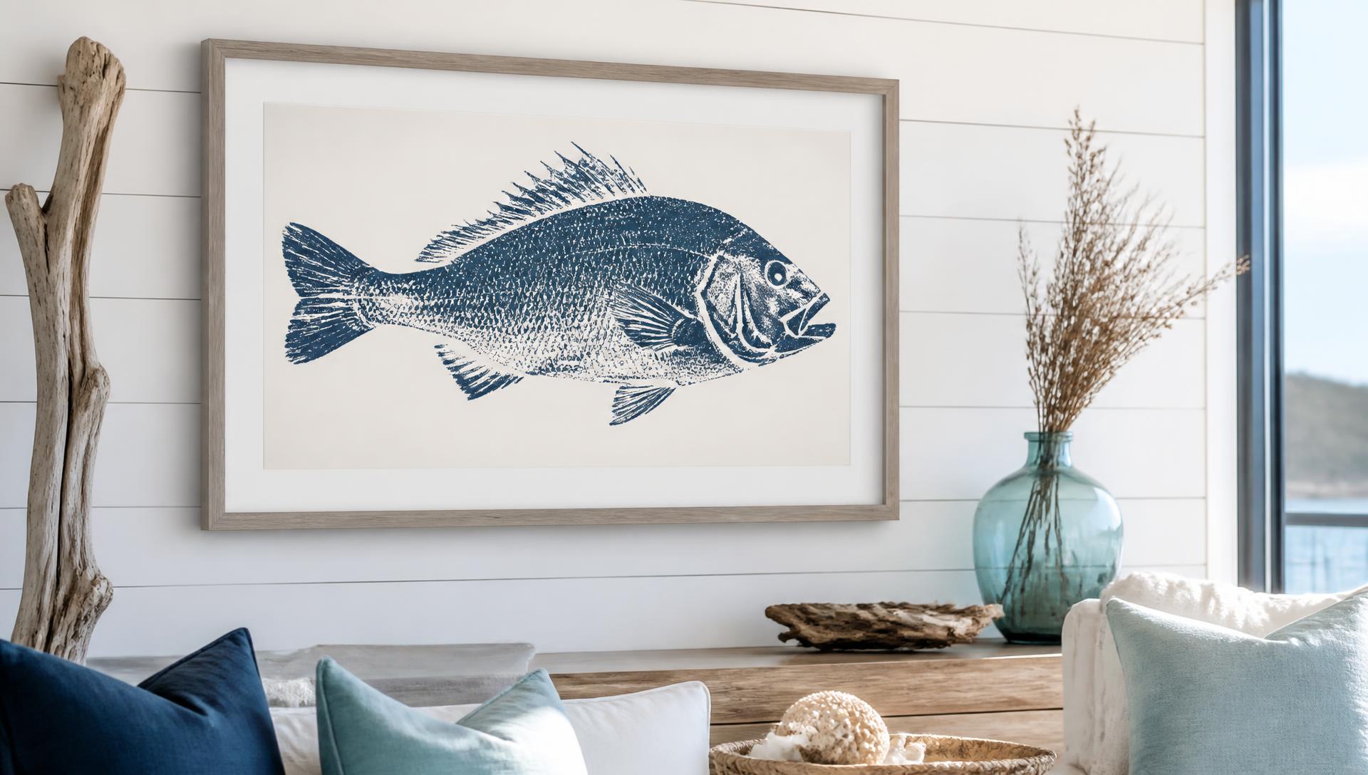 Framed Gyotaku fish print hanging on a white shiplap wall in a coastal home